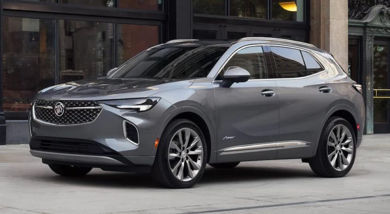 A grey 2022 Buick Envision Avenir is shown on a city street after visiting a Buick dealership.