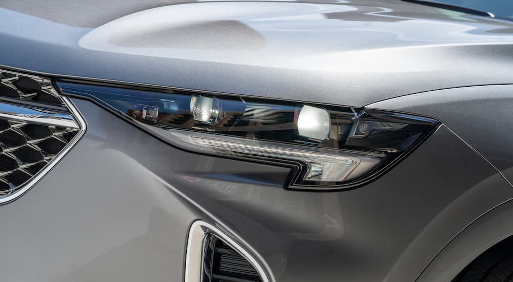 A close up shows the drive side headlight on a grey 2022 Buick Envision Avenir.