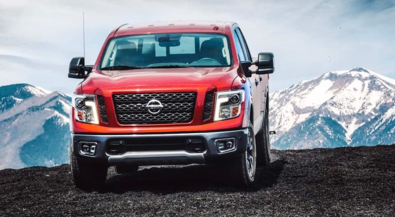 A red 2018 Nissan Titan is shown parked with a mountain view.