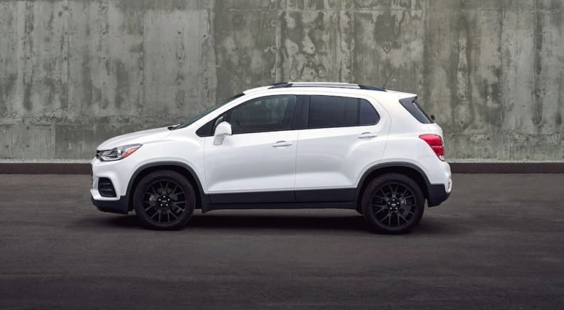 A white 2022 Chevy Trax is shown parked in front of a cement wall.