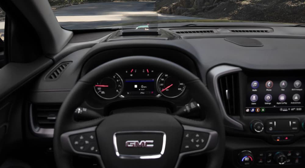 The black interior of a 2022 GMC Terrain AT4 shows the steering wheel.