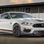 A grey 2022 mustang Mach 1 is shown from the front at an angle on a race track after the owner searched "used cars near me"..