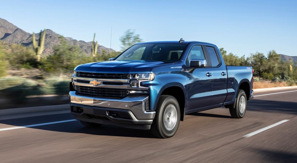 A blue 2019 Chevy Silverado 1500 is shown driving on an open road.