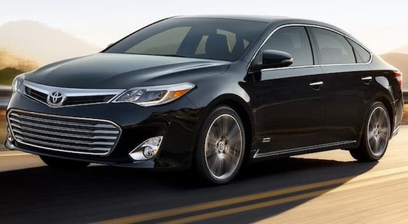 A black 2017 Toyota Avalon is shown from the front at an angle while driving down the road after leaving a used Toyota dealer near you.