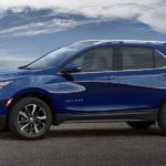 A blue 2022 Chevy Equinox is shown from the side parked in front of a body of water.
