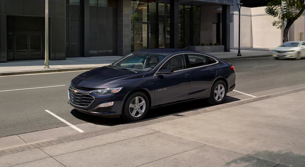 A black 2022 Chevy Malibu is shown parked on a city side street.