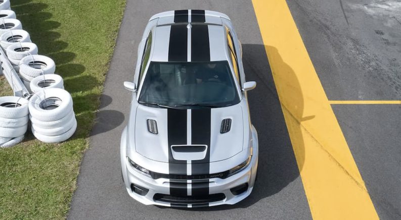 A white and black 2022 Dodge Charger is shown from the front parked at a racetrack.