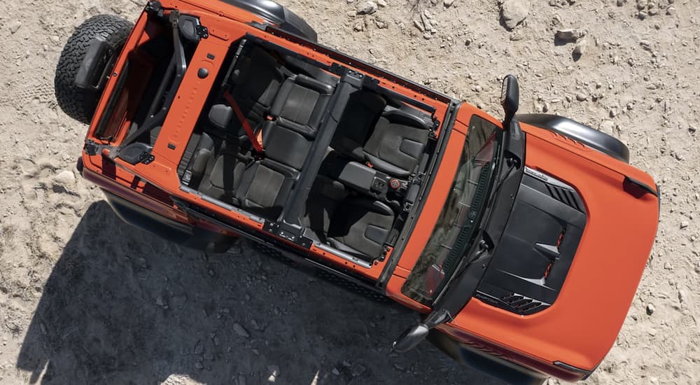 An orange 2022 Ford Bronco is shown from above parked in the sand.
