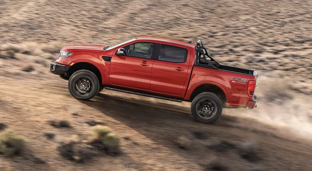 A red 2022 Ford Ranger is shown off-roading in a desert.