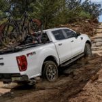 A white 2022 Ford Ranger is shown off-roading up a hill during a 2022 Ford Ranger vs 2022 Chevy Colorado comparison.