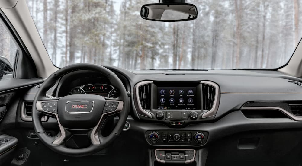 The black interior of 2022 GMC Terrain shows the steering wheel and infotainment screen.