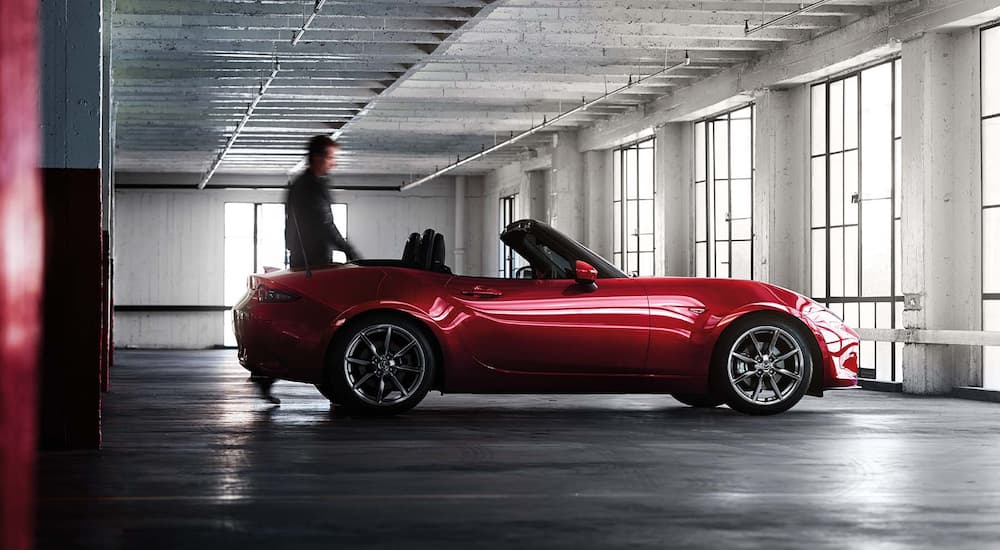 A person is shown approaching a 2022 Mazda MX-5 Miata in a parking garage. 