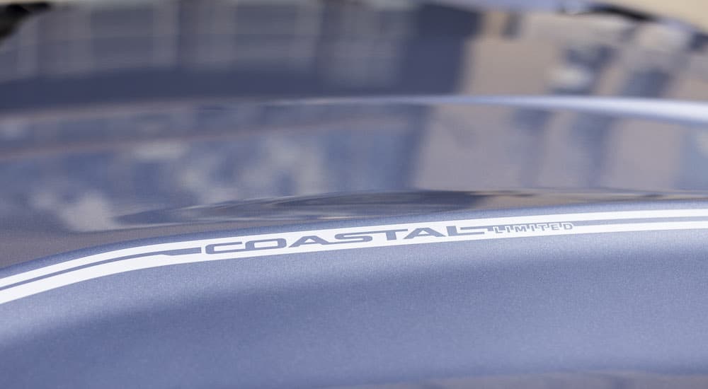 A close up shows the 'coastal limited' badging on the hood of silver 2022 Mustang Coastal Limited Edition.