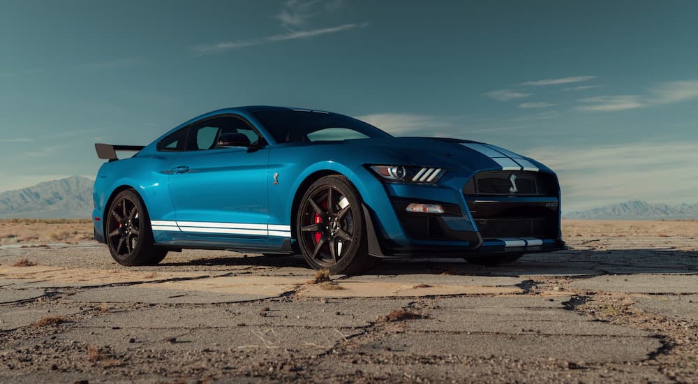 A blue 2022 Mustang Shelby GT500 Carbon Fiber Track Package is shown parked on dirt.