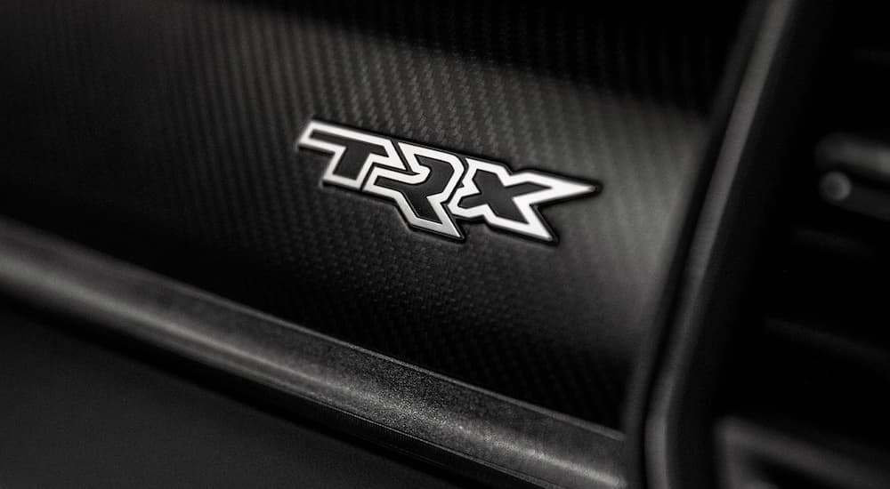 A close up shows the white TRX badge on the dash of a 2021 Ram 1500 TRX.