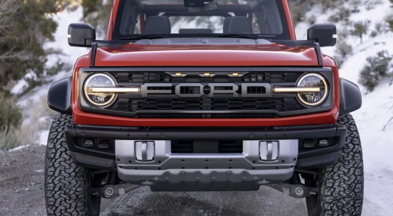 A red 2022 Ford Bronco is shown from the front parked in the mountains.