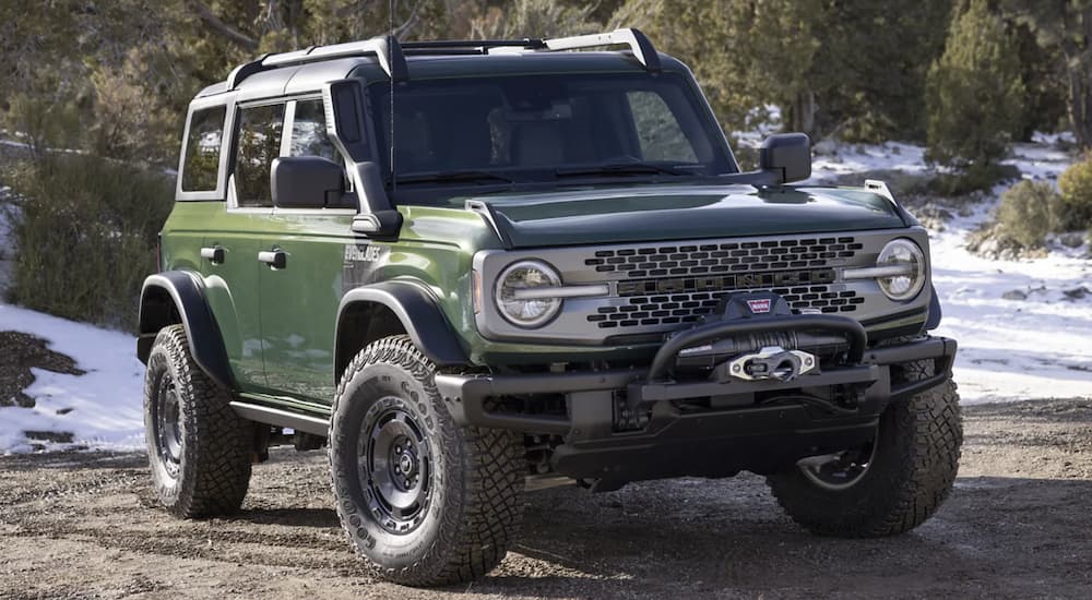 A green 2022 Ford Bronco is shown from the front parked in the mountains.