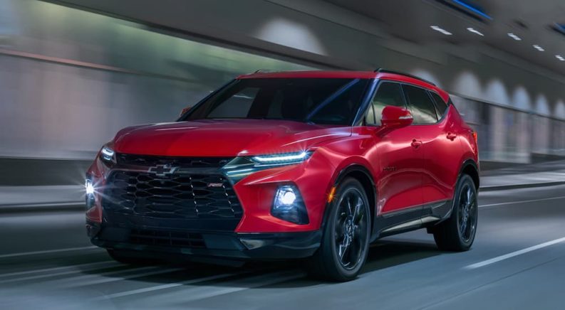A red 2023 Chevy Blazer is shown driving from the front at an angle.