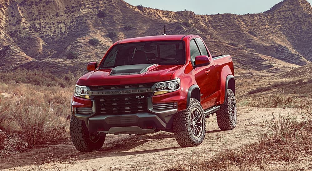 A red 2021 Chevy Colorado ZR2 is shown from the front while parked in the desert after leaving a used truck dealer.