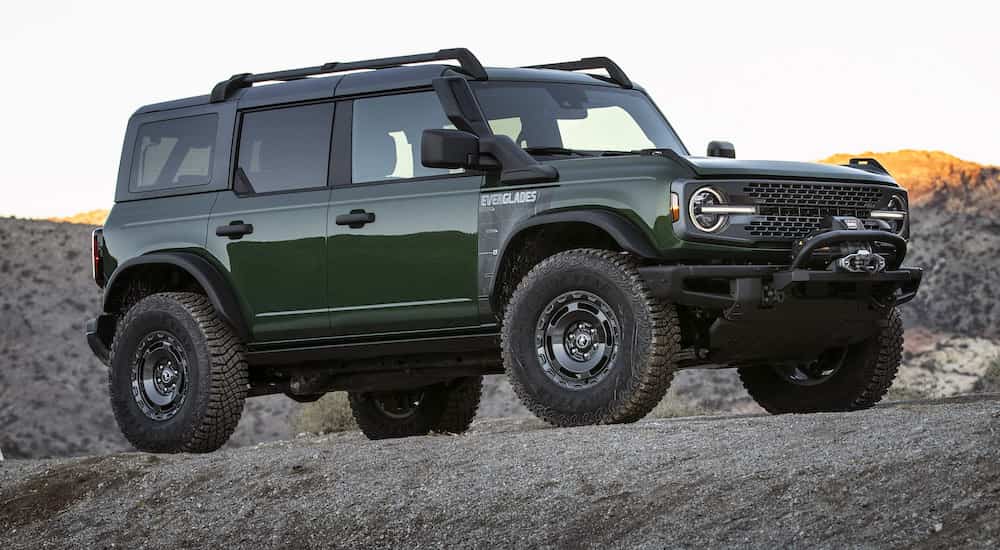 A green 2022 Ford Bronco Everglades is shown from the side at an angle while parked offroad.