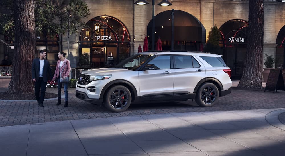 A white 2022 Ford Explorer ST is shown outside a pizza restaurant.