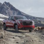 A red 2022 GMC Sierra AT4X is shown from the front while driving through the mountains after leaving a South Carolina GMC dealer.