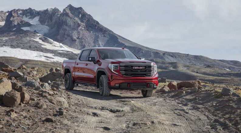 A red 2022 GMC Sierra AT4X is shown from the front while driving through the mountains after leaving a South Carolina GMC dealer.