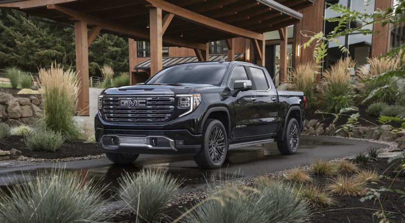 A black 2022 GMC Sierra 1500 Denali Ultimate is shown from the front at an angle while parked in front of a house after leaving a Murfreesboro GMC dealer.