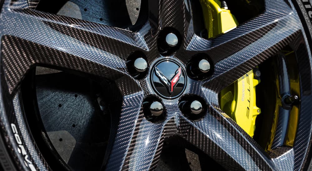A close up shows the carbon fiber wheel and yellow caliper on a 2023 Chevy Corvette Z06.