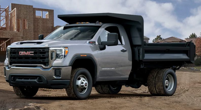 A grey 2022 GMC Sierra 3500 dump body is shown from the front at an angle during a 2022 GMC Sierra 3500 HD vs 2022 Ram 3500 comparison.