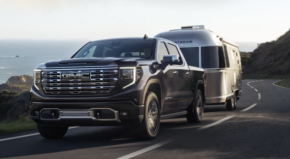 A black 2022 GMC Sierra 1500 Denali is shown from the front towing an airstream after leaving a GMC dealer.
