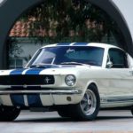 A white 1965 Ford Mustang GT350 is shown from the front at an angle after the owner searched 'sell my car'.