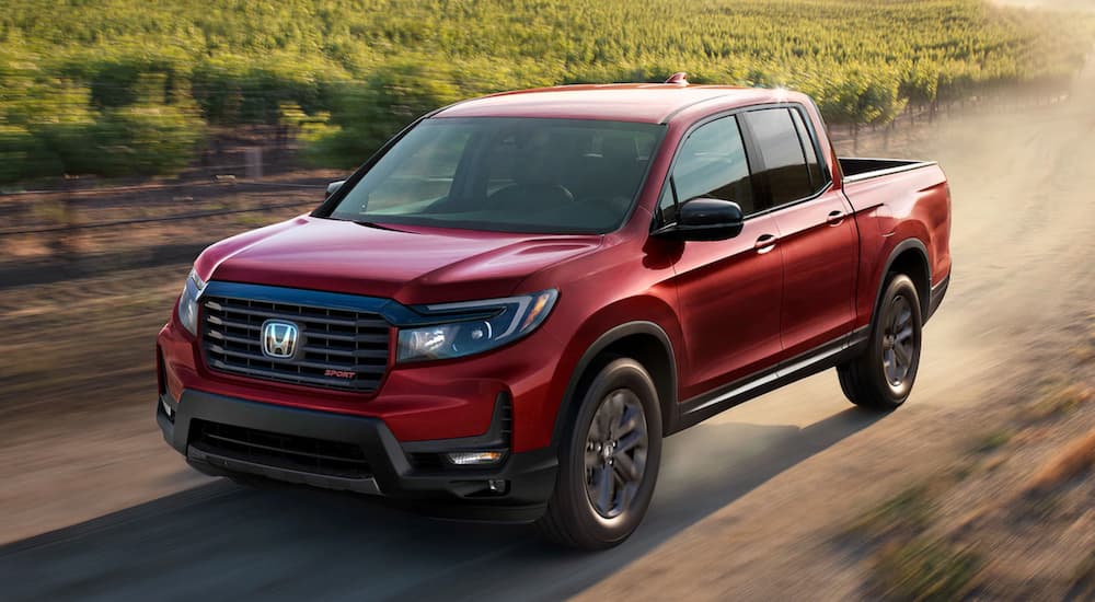 A red 2021 Honda Ridgeline Sport is shown from the front at angle after leaving a used Honda dealership.