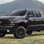 A black 2022 Chevy Silverado 1500 is shown from the side parked in a field.