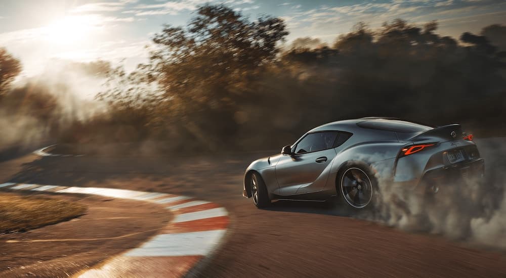A silver 2020 Toyota Supra GR is shown from the rear on a racetrack.