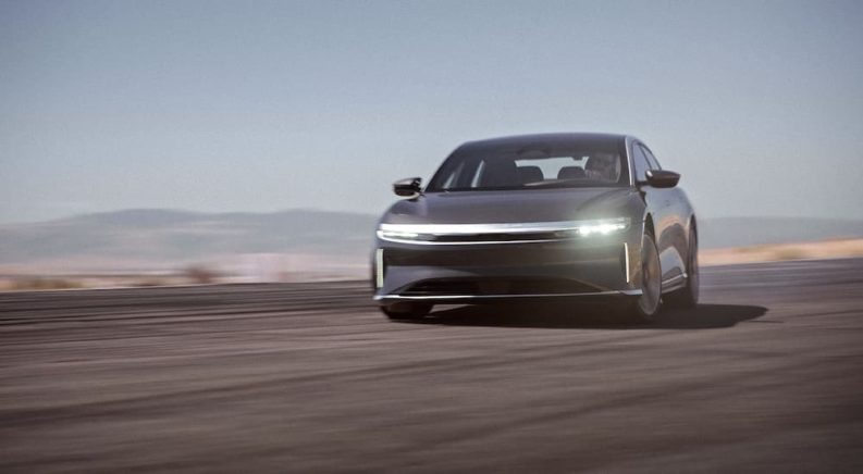 A grey 2022 Lucid Air GT is shown from the front while driving on a desert road.