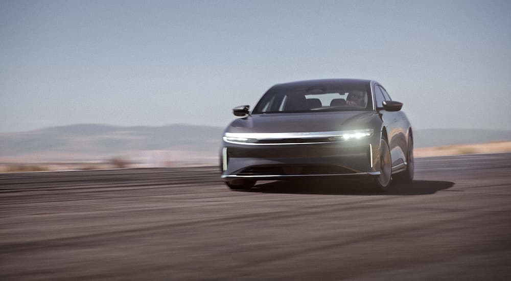 A grey 2022 Lucid Air GT is shown from the front while sliding through a corner.