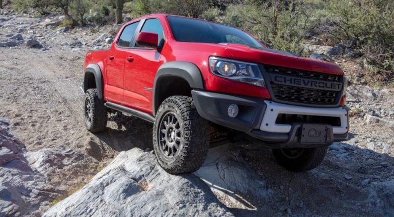 A red 2022 Chevy Colorado ZR2 Bison is shown from the front at an angle during a '2022 Chevy Colorado vs 2022 Toyota Tacoma' comparison.