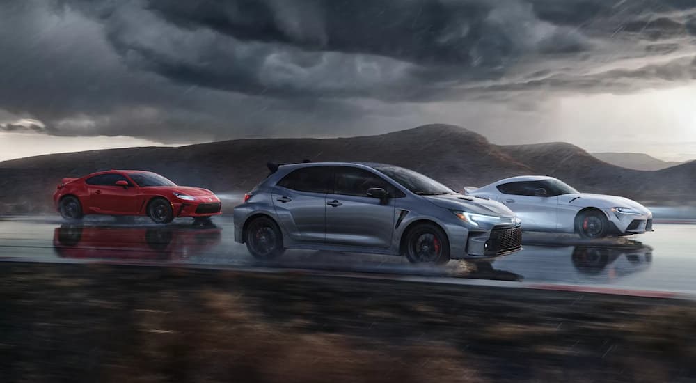 A silver 2023 Toyota GR Corolla is shown with a white 2022 GR Supra and a red 2022 GR 86 on a race track.