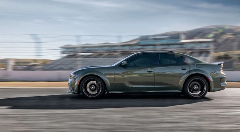 A green 2021 Dodge Charger RT is shown from the side driving on a track.