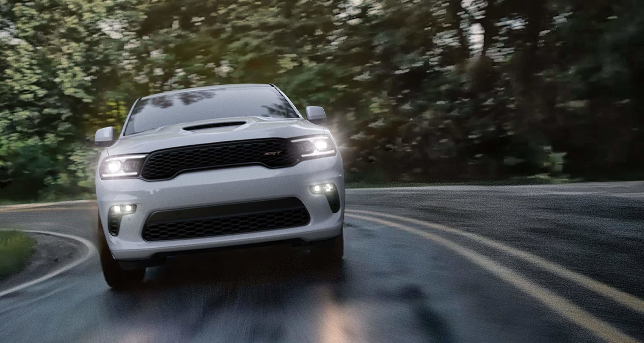A white 2022 Dodge Durango SRT is shown from the front driving to a Dodge dealer near you.
