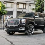 A black 2019 GMC Yukon Denali Ultimate is shown parked on a city lot after leaving a GMC dealer.