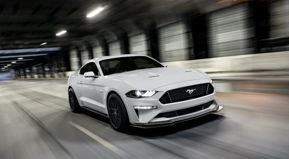 A white 2020 Ford Mustang GT is shown driving through a tunnel.