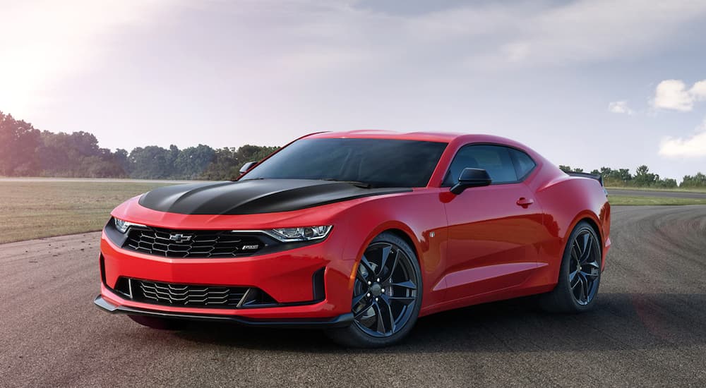 A red 2020 Chevy Camaro RS is shown from the front at an angle while parked in a lot after leaving a Chevy Dealer.
