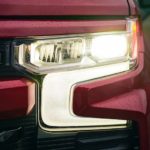 A close up of the headlight of a red 2022 Chevy Silverado 1500 RST is shown.