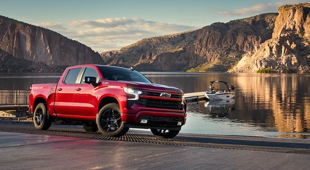 A red 2022 Chevy Silverado 1500 RST is shown parked near a body of water.