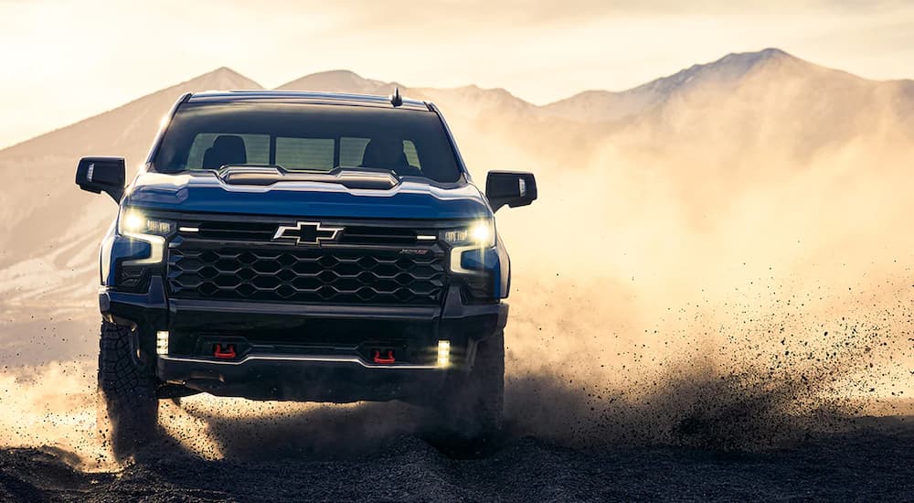 A blue 2022 Chevy Silverado 1500 ZR2 is shown from the front kicking up dust.