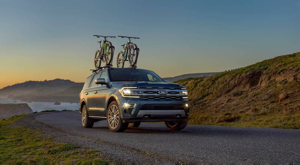 A dark blue 2022 Ford Expedition Platinum is shown with bikes on the roof.