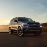 A dark grey 2022 Ford Expedition Stealth Edition is shown overlooking a bay.