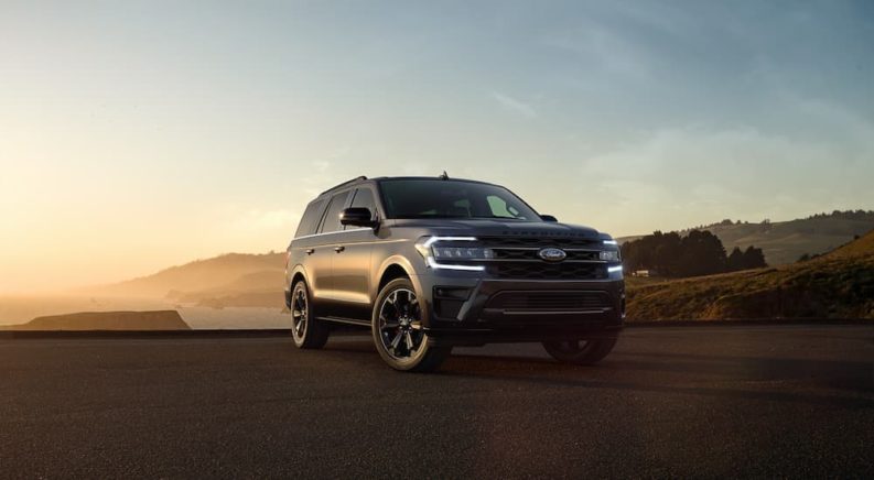 A dark grey 2022 Ford Expedition Stealth Edition is shown overlooking a bay.